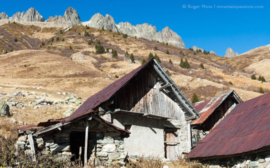 Group of abandoned chalets with iron roofs on mountainside