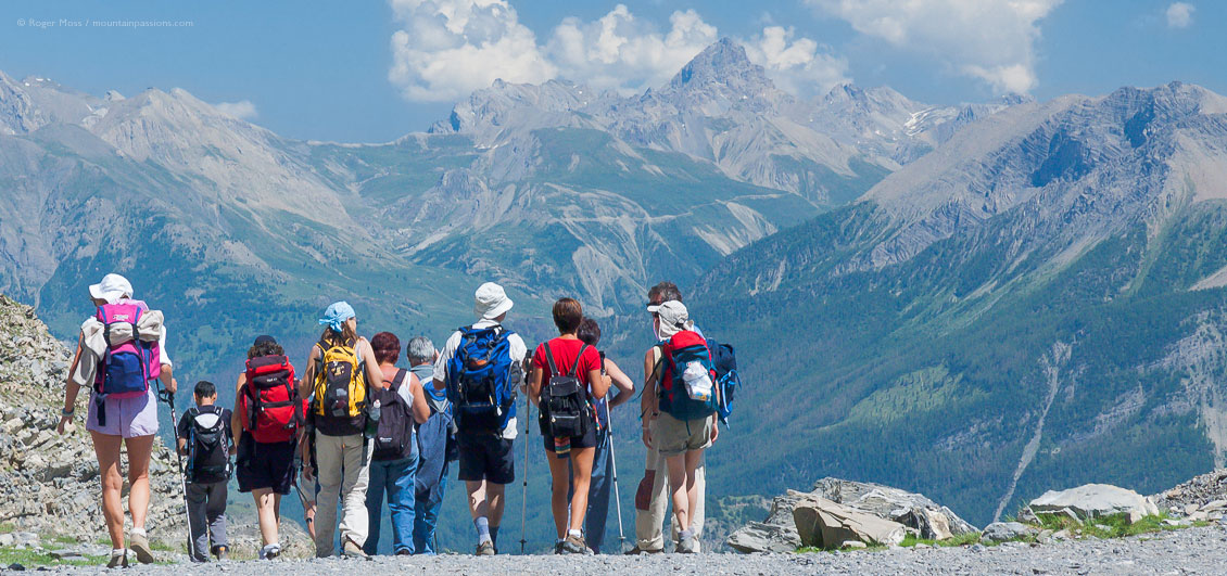 Wide view of group of walkers looking at mountain scenery