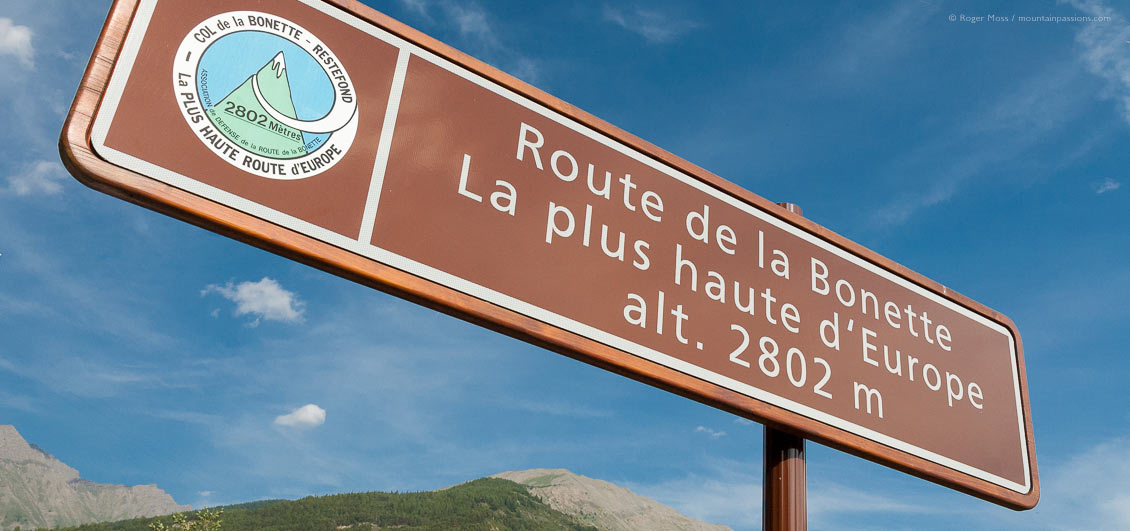 Low view of Route de la Bonette road sign with mountains