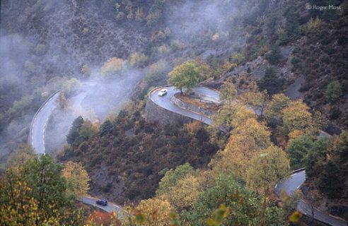 Cars negotiating one of the hairpin sections below the Col de Turini