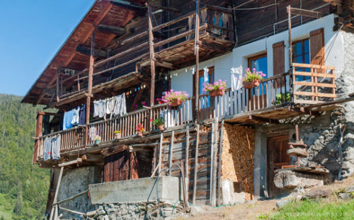 View past firewood stacked on front of grenier to traditional mountain chalet in the Beaufortain, French Alps.