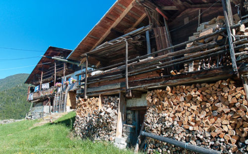 View past firewood stacked on front of grenier to traditional mountain chalet in the Beaufortain, French Alps.