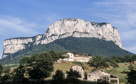 Low view of farmhouses against limestone outcrop in summer