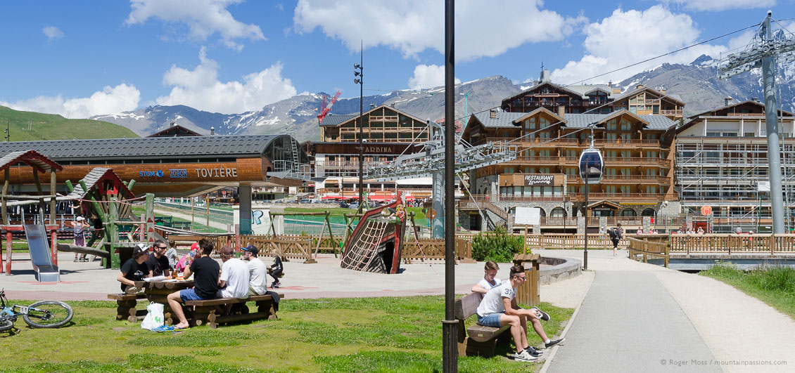 View of apartments and chairlifts with summer visitors in Tignes