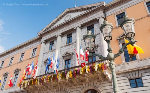 Low view of Annecy Hotel de Ville facade with flags