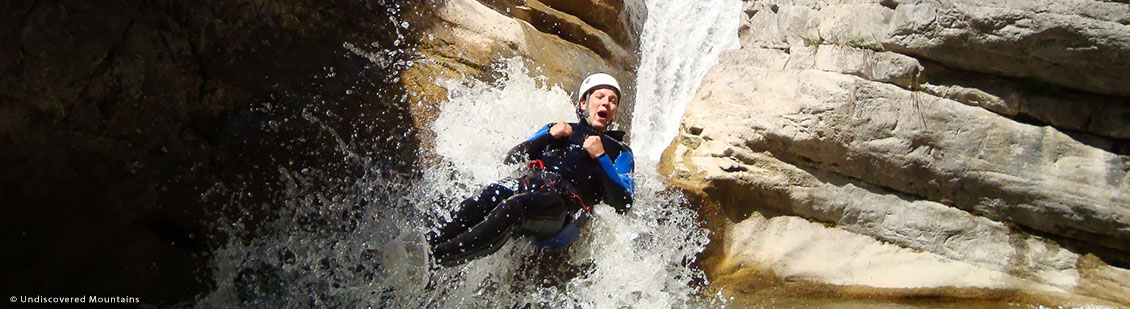 Canyoning - sliding down a waterfall in the southern French Alps.