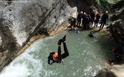 Big dive into a pool with canyoning group in the southern French Alps.