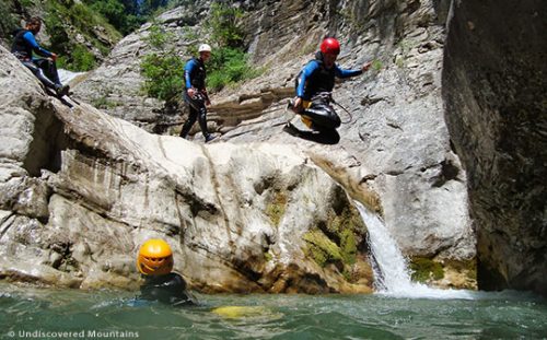 Group canyoning, jumping into pool.