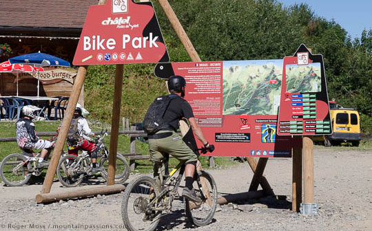 Mountain biker looking at map of Chatel bike park, French Alps