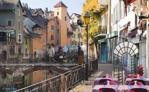 The quayside restaurant terraces look inviting, whether sunlit or illuminated at nightfall, Annecy