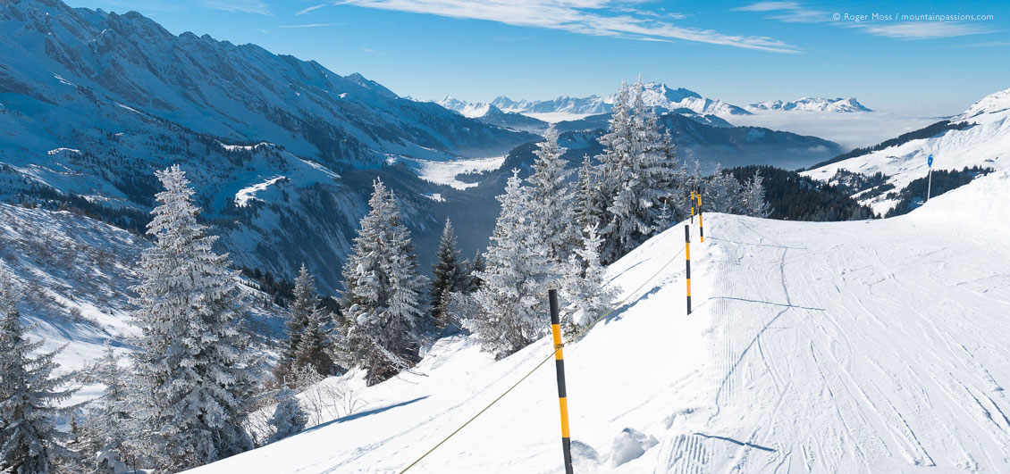 Skier's view of fresh snow on mountains and valley at Le Grand Bornand