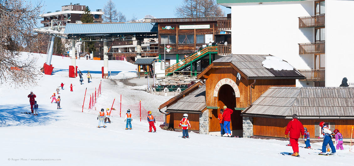 Children going to ski lesson, with chair lift and village in background