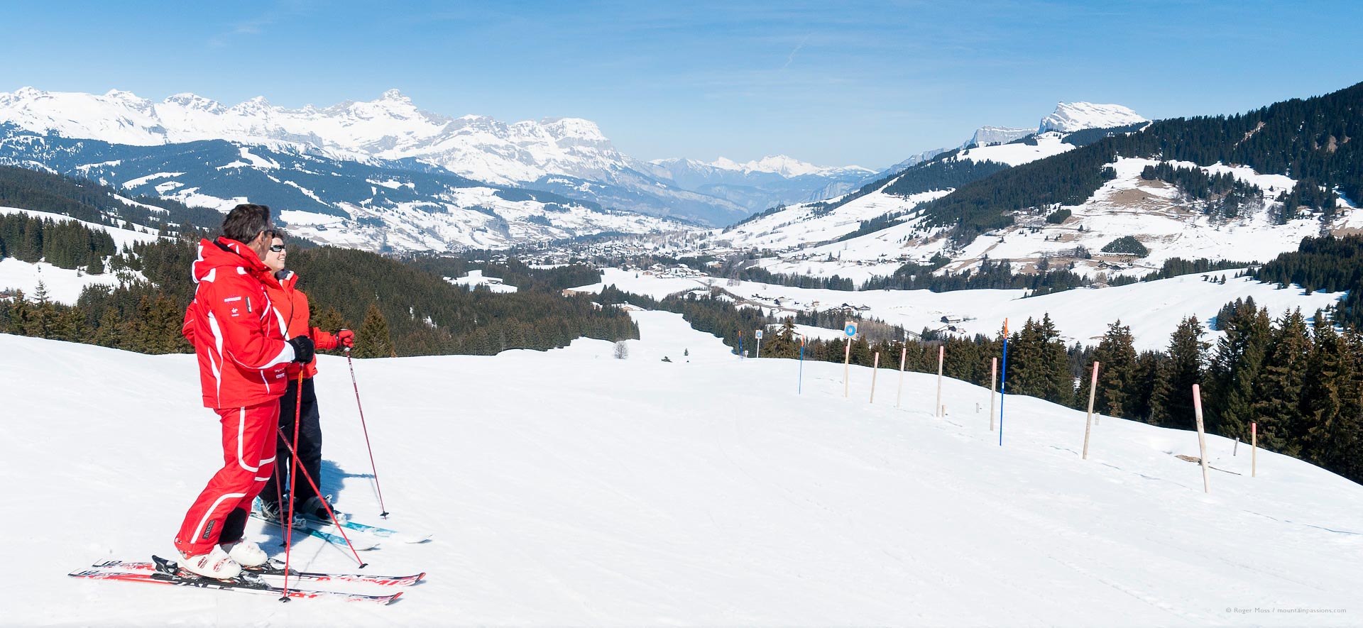 Skier and ski instructor looking at views of the Val d'Arly