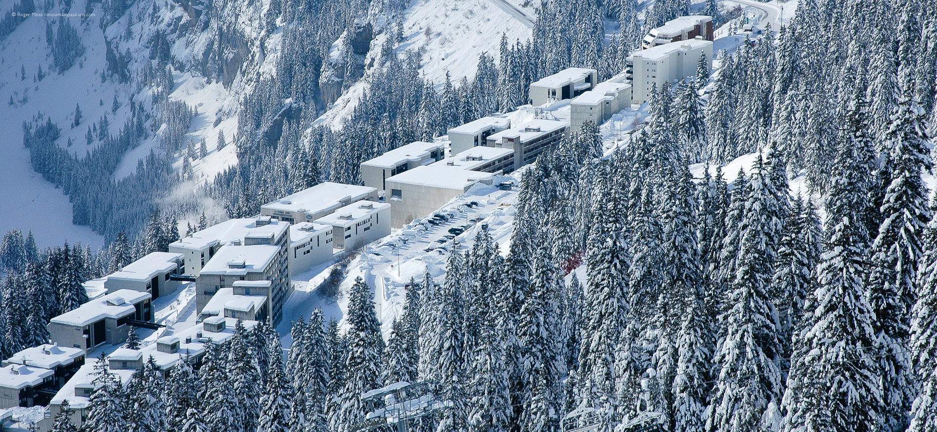 Bird's-eye view of snow-covered apartment blocks an pine forests at Flaine-la-Foret, French Alps.