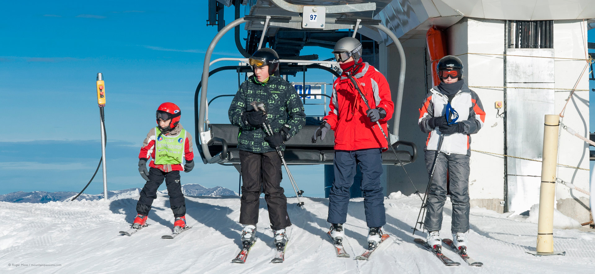 Skier family leaving top station of chair lift