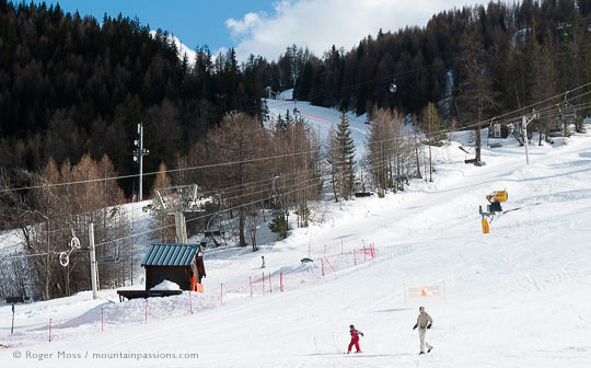 Family walking on ski piste with chairlift and forest 