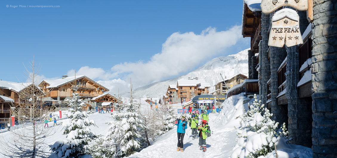 Skiers walking through Sainte Foy Tarentaise ski village, French Alps.