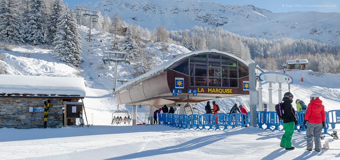 Skiers and snowboarders beside ski lift at Sainte Foy Tarentaise, French Alps.