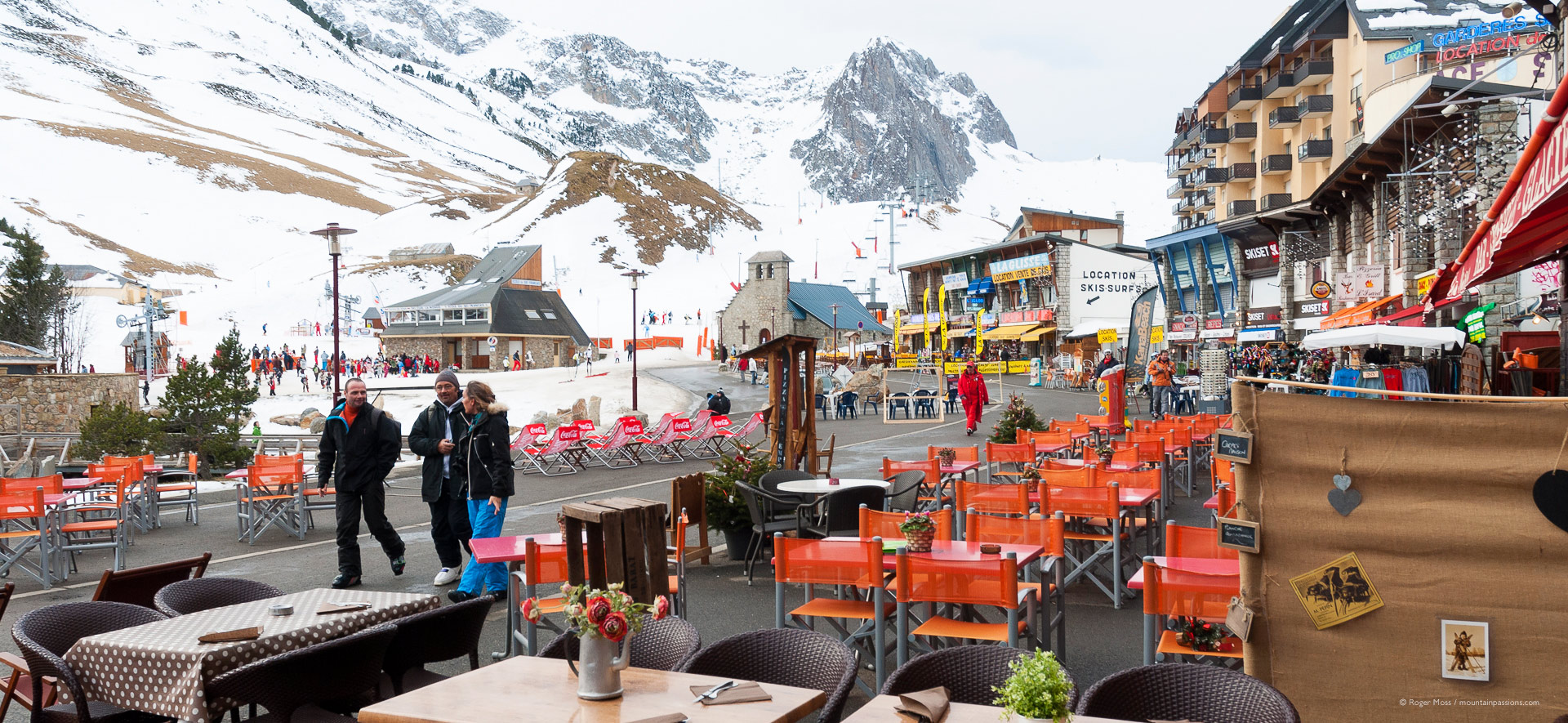 View of village facades and visitors from restaurant terrace.