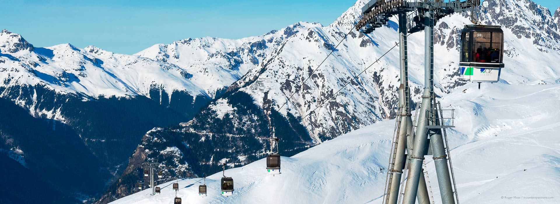 View of gondola lift from Oz-en-Oisans to the ski area of l'Alpe d'Huez, showing valley.