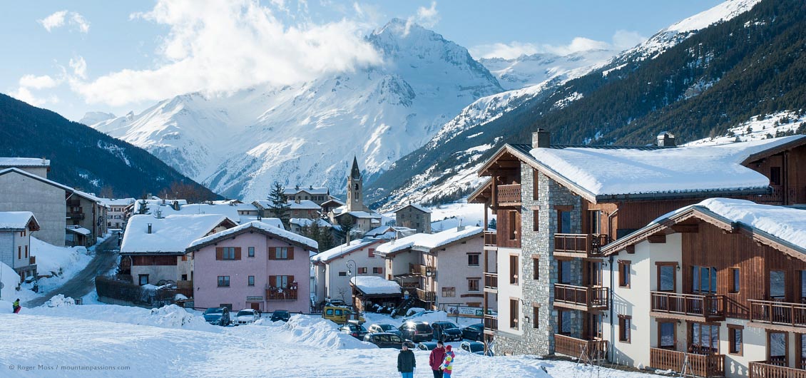 View of snow-covered village rooftops with mountainside