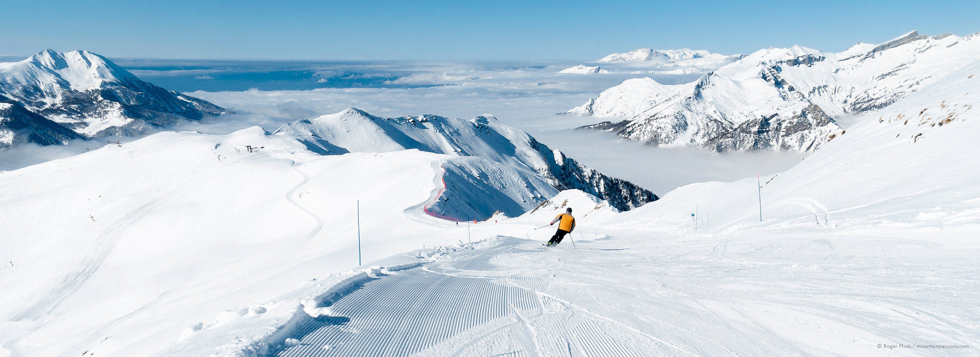 View of skier on wide piste above the clouds at Orcierès 1850.