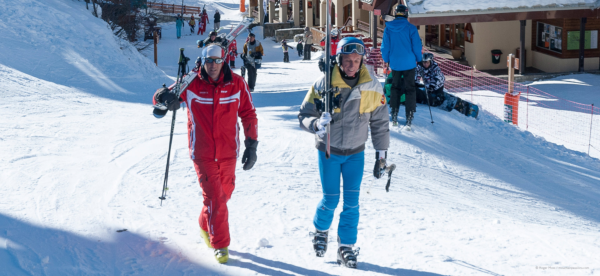 Skier with instructor walking through village