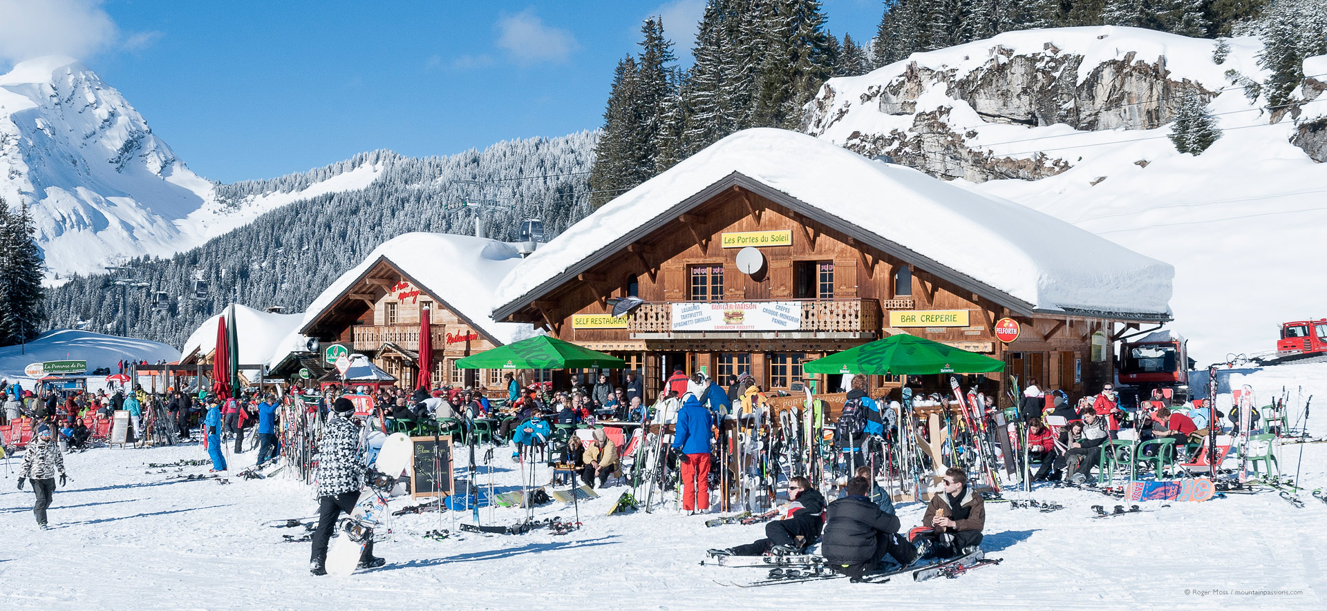 Large groups of skiers outside mountain restaurants