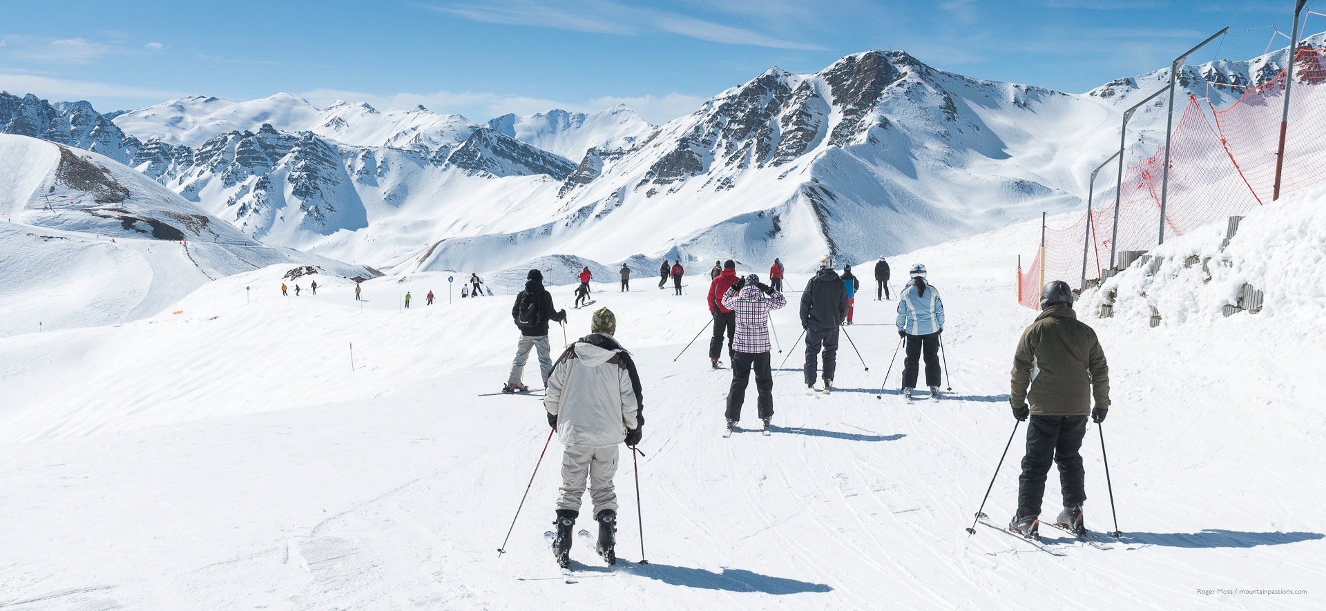 Groups of skiers on wide piste between ski areas