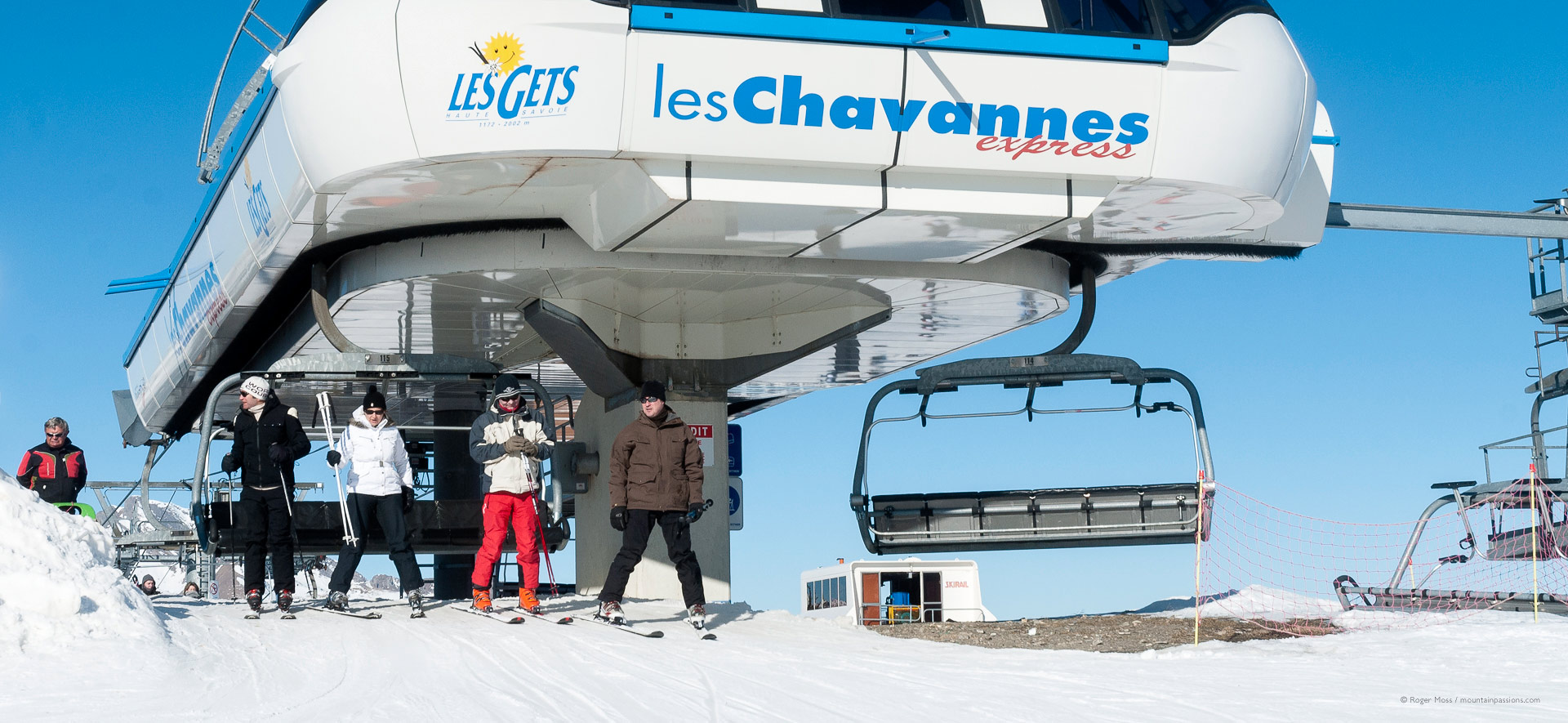 Skiers leaving high-speed chairlift above Les Gets.