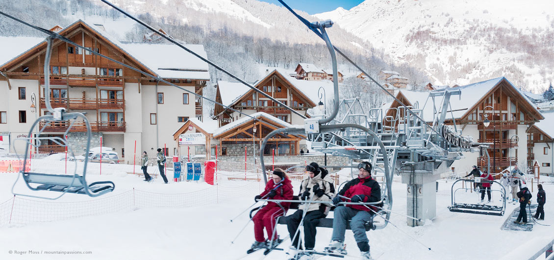 Skiers on chairlift leaving ski village