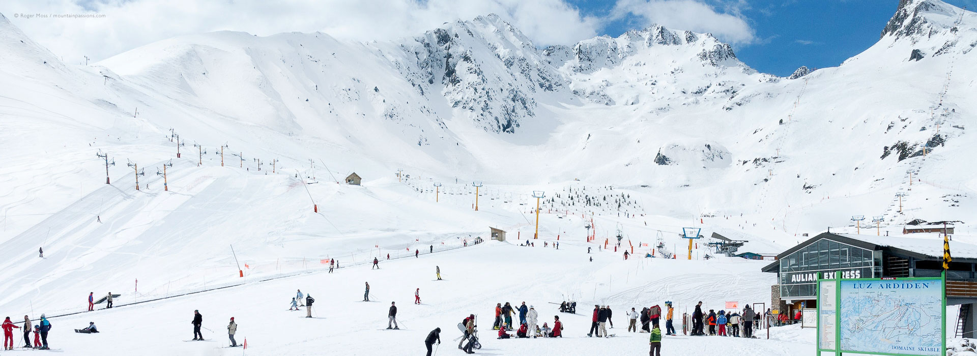 View of front-de-neige area, with skiers, chairlift and mountain background at Luz Ardiden