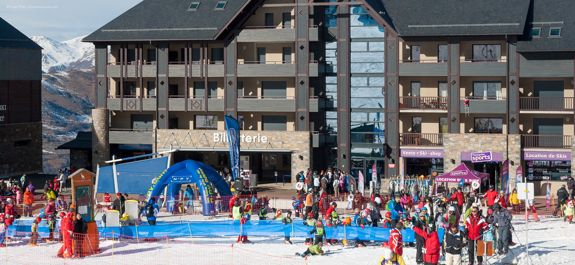 Skiers with beginner area and apartment buildings