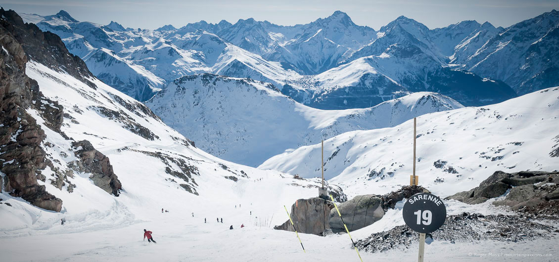 Overview of skier on La Sarenne black piste with big mountain views