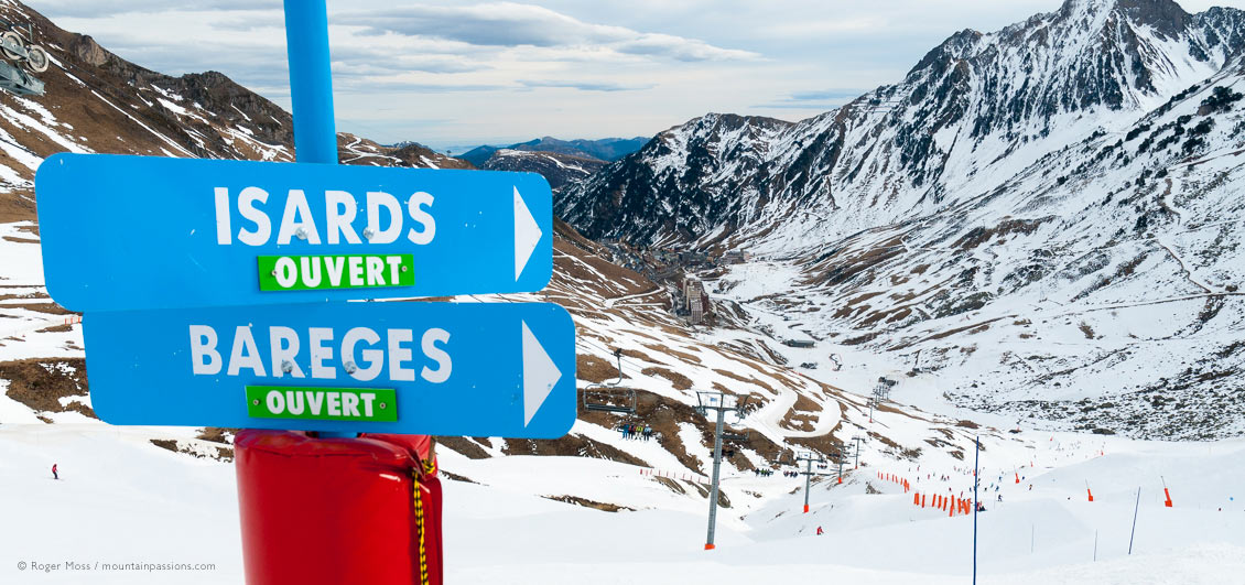 View from Col du Tourmalet with piste sign and La Mongie ski resort