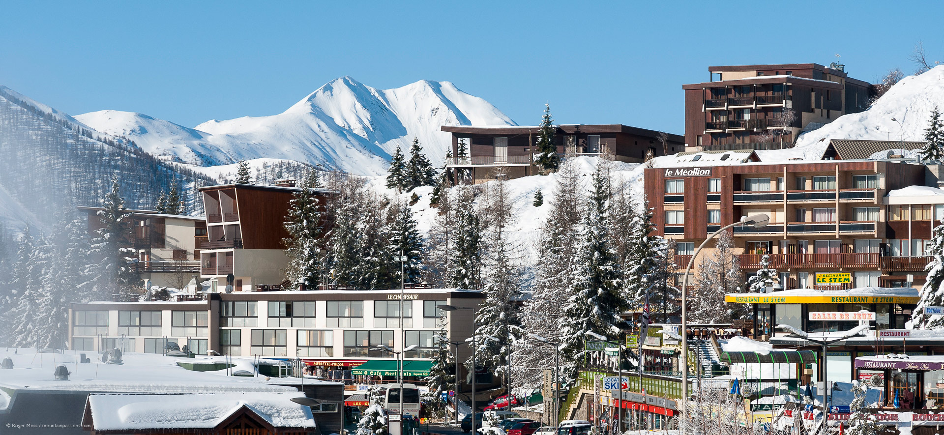 Side view of ski village with snow-covered trees and mountains