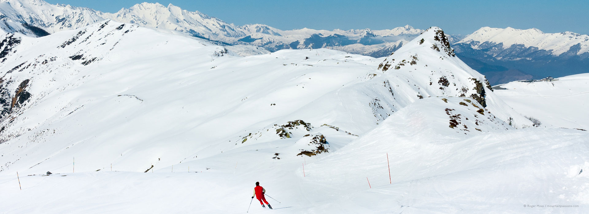 Wide view of mountain scenery with skier on piste at Hautacam.