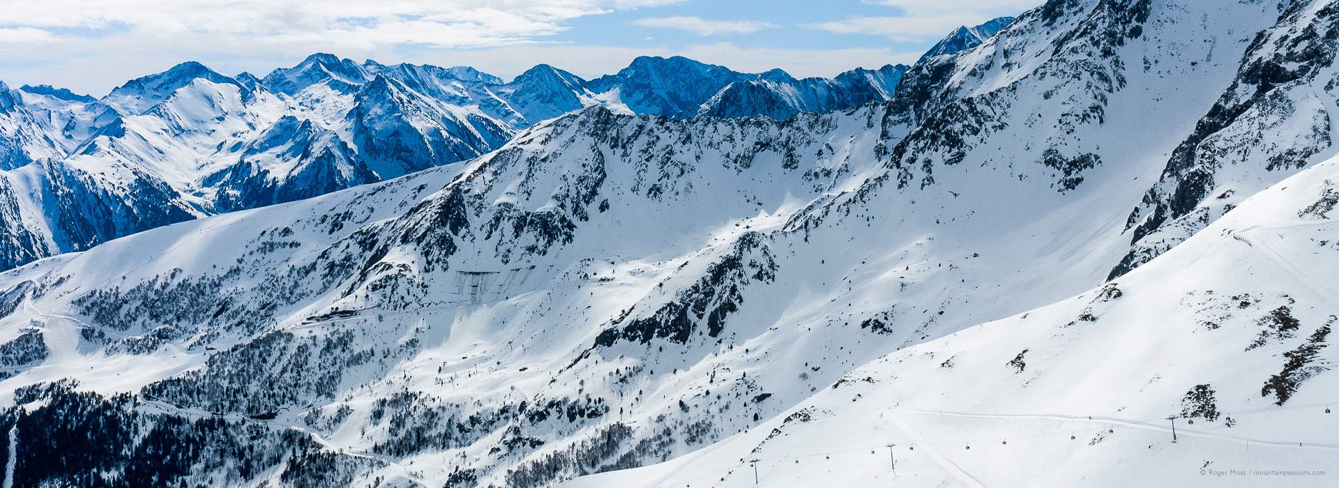 Overview of mountain landscape, showing ski lifts and pistes above Saint Lary Soulan.