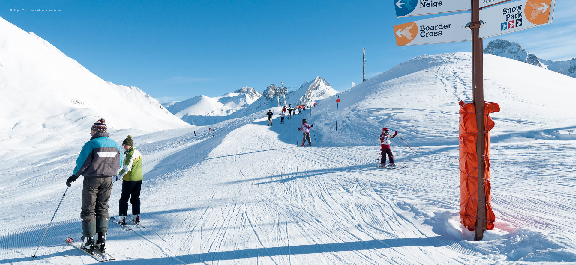 Older skiers being passed by ski school children's group