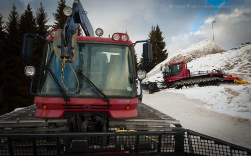 Two piste-groomers parked in snow