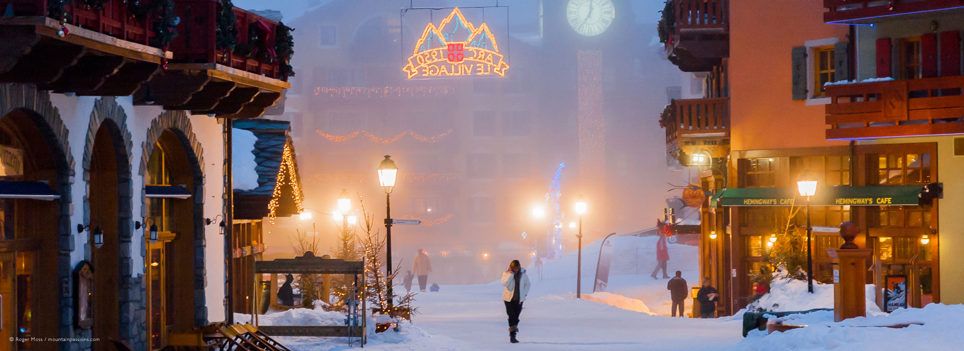 Snowy heart of Arc 1950 ski village at dusk with families