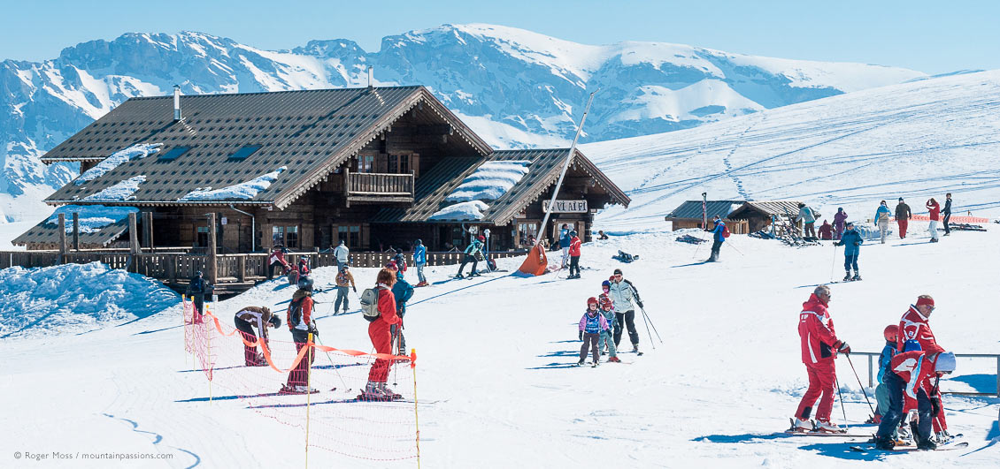 Young skiers with ski instructors beside mountain restaurant at Le Devoluy.