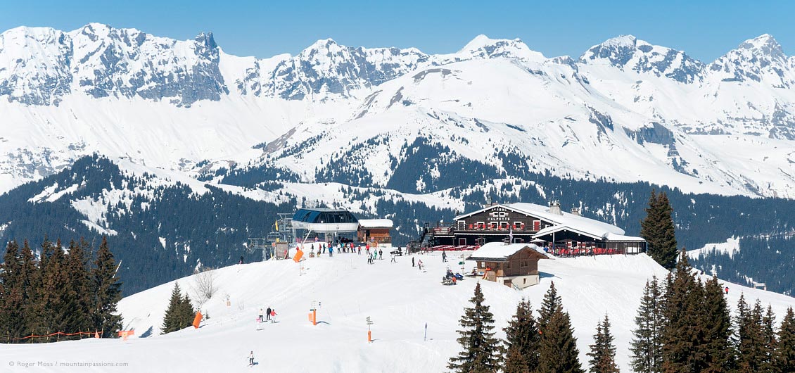 High view of l'Alpette mountain restaurant with skiers and chair-lift
