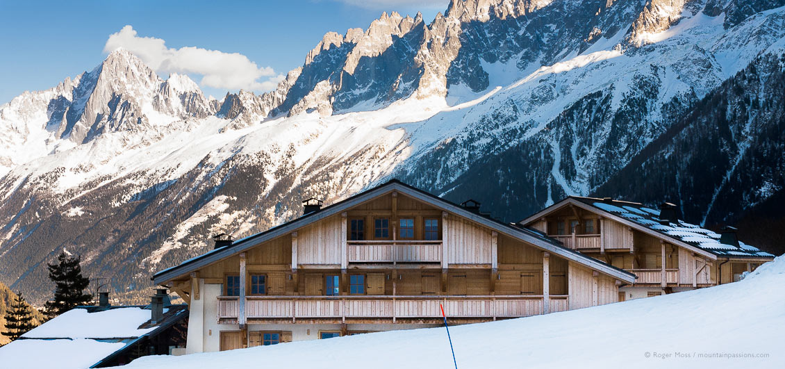 Piste-side, chalet-style apartments with mountains in late afternoon light above Les Houches