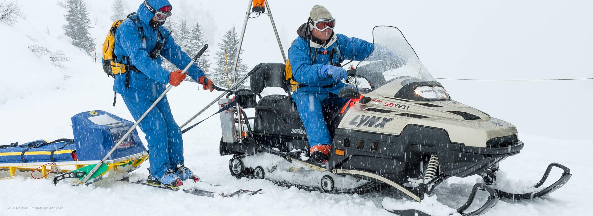 Behind the scenes ski patrol team with snowmobile practice with an accident recovery sled