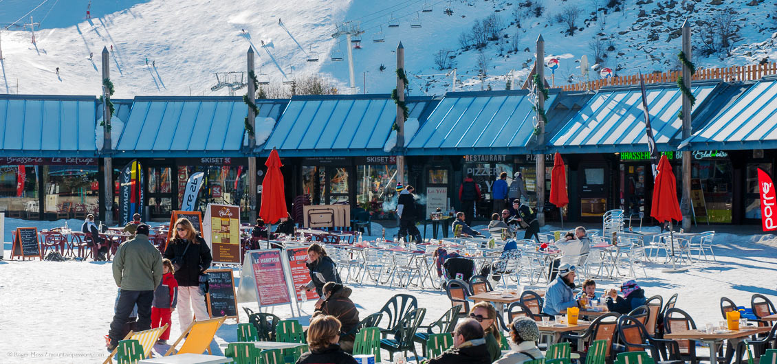 Visitors at cafe tables in centre of ski village at Piau Engaly