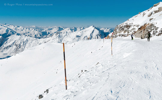 Wide view from piste of skier and snowboarder above Les Menuires