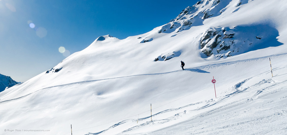 Long view of skier off piste in bright sunlight at Serre Chevalier