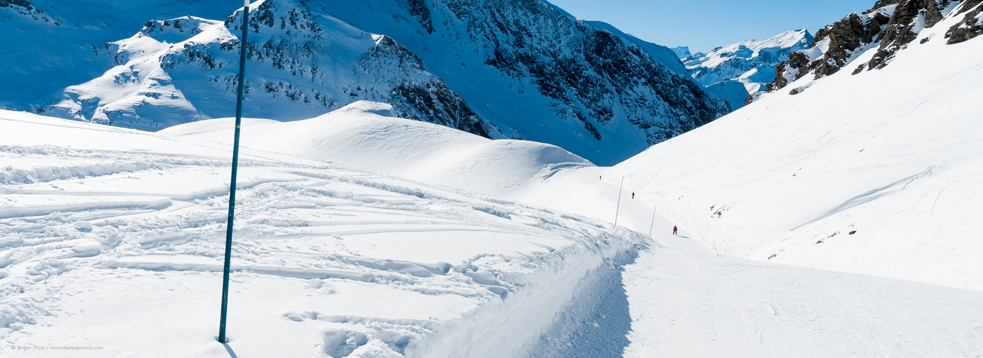 Low, wide skier's-eye view ofpiste and snow-covered mountains at Valfrejus