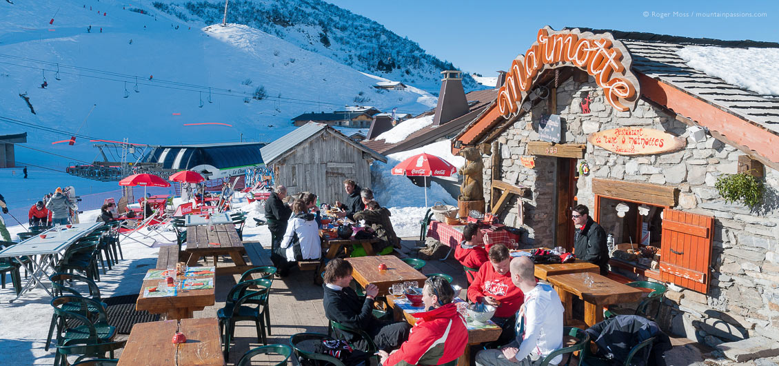 View of skiers in sunshine at mountain restaurant above Chatel, Portes du Soleil
